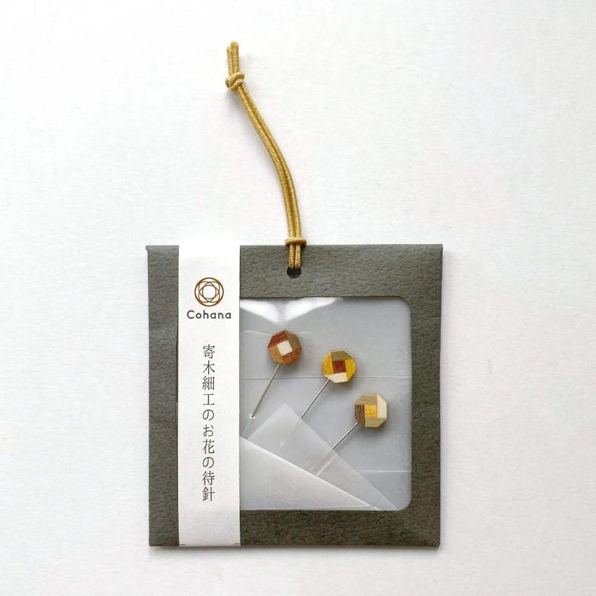 a pair of earrings in a package on a white background