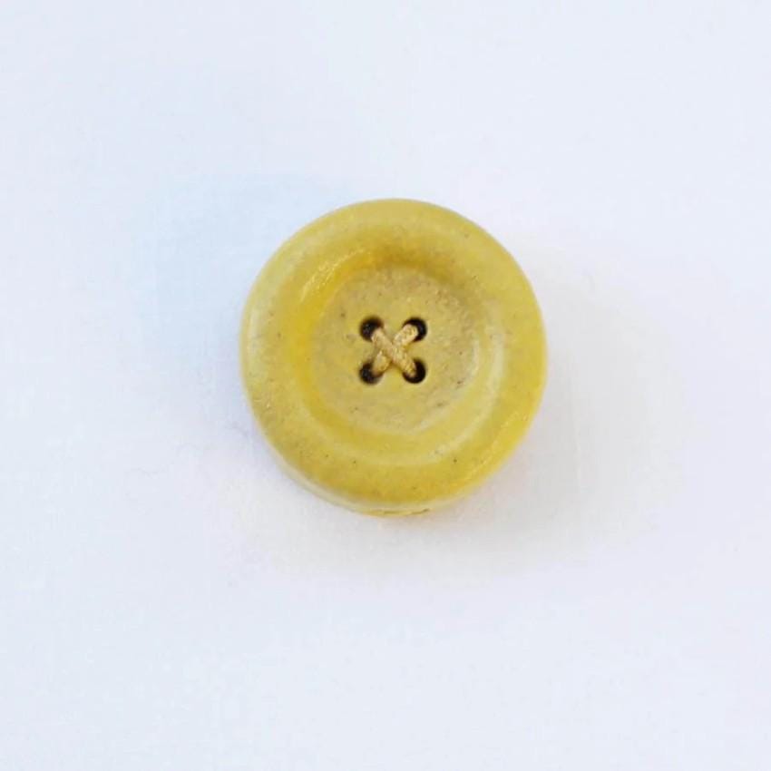 a yellow button with a four - leaf clover on it