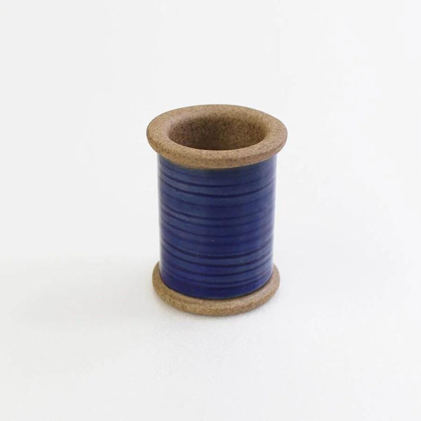 a spool of blue thread on a white background