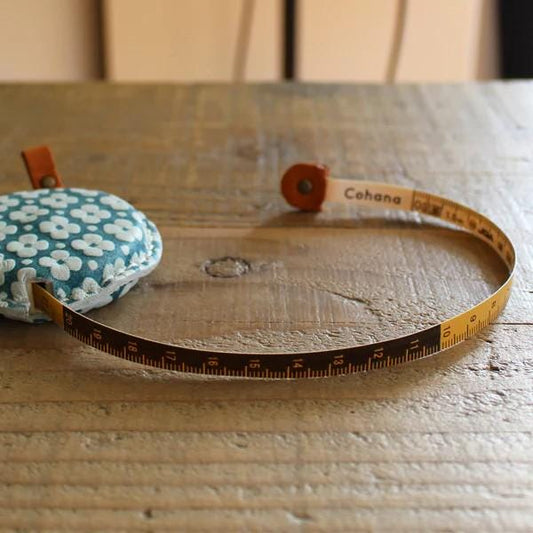 a measuring tape and a pillow on a wooden table