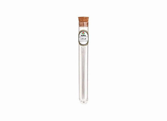 A clear glass tube with a cork stopper, containing a small amount of what appears to be a liquid or powder.