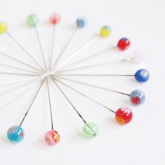 A collection of colorful glass beads arranged in a circular pattern on a white background.