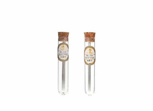 Two glass tubes with metal needles, each with a cork stopper, are shown against a white background.