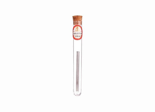 A clear glass tube containing a silver object, with a red and white label on the tube.