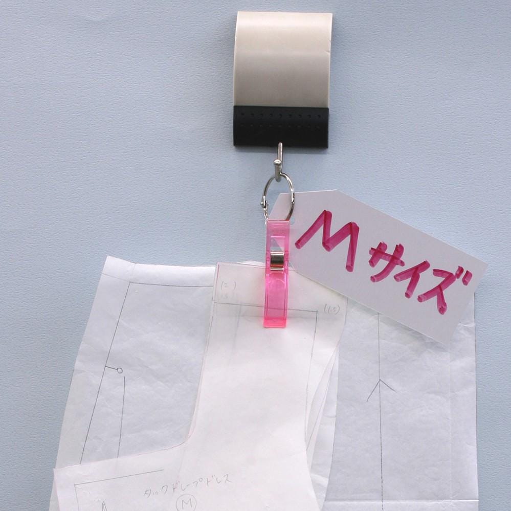 a pink clip holding a piece of paper with Japanese text, and there is a piece of paper with a drawing and some text on it.