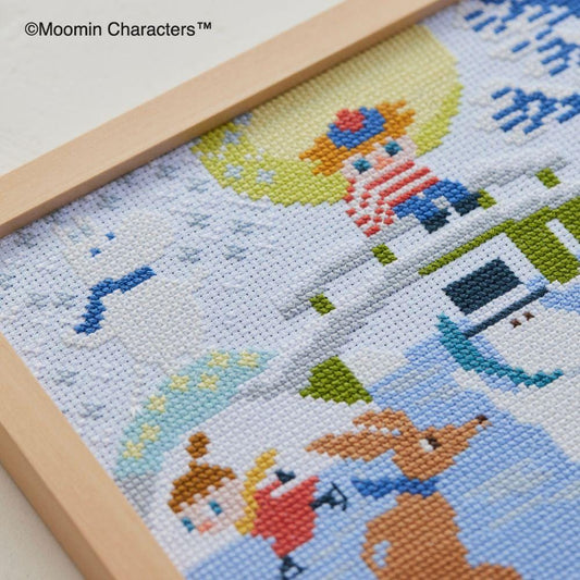 The image is a cross-stitch embroidery depicting various characters and scenes, including a dog, a person, and a snowy landscape.