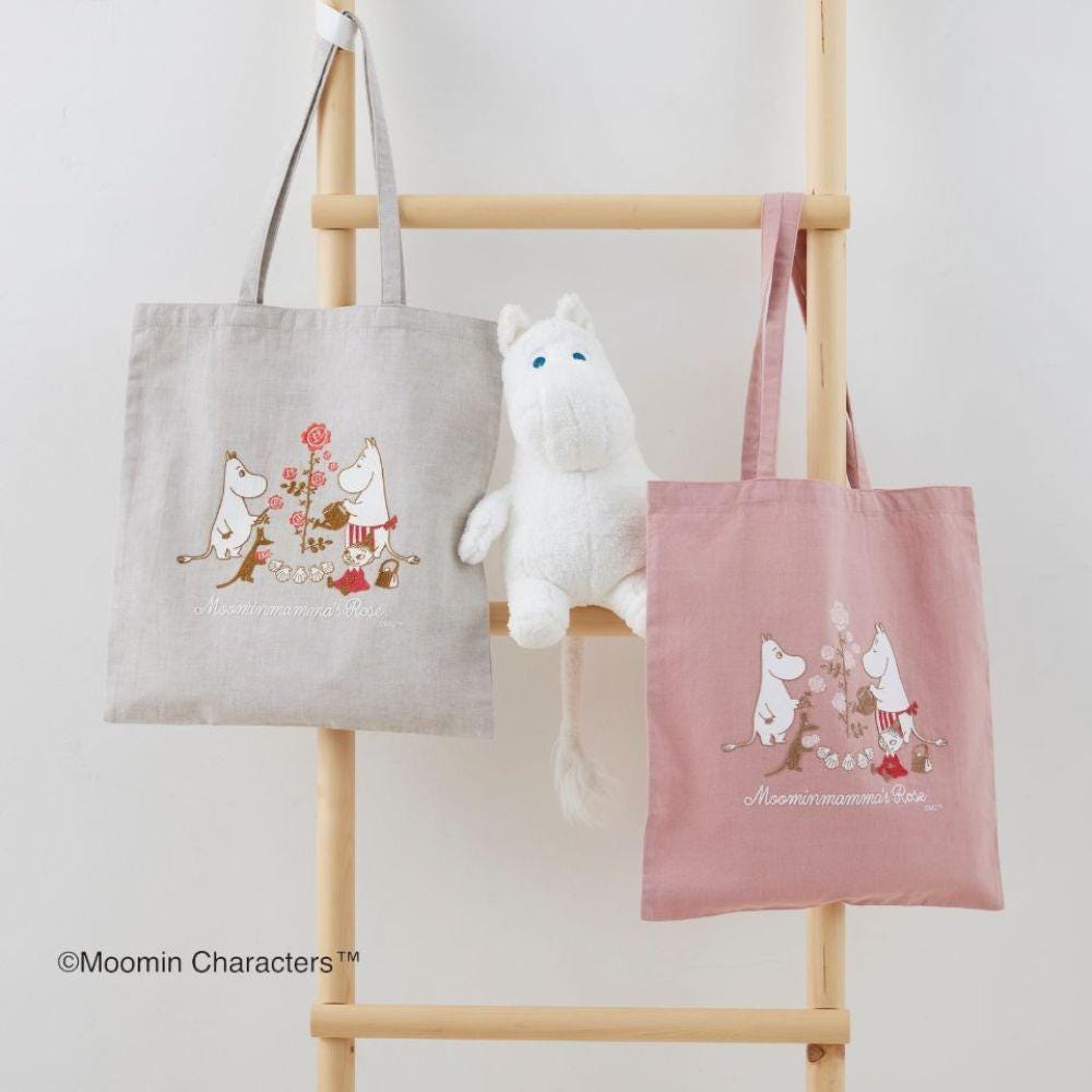 two tote bags with Moomin characters printed on them, along with a stuffed animal resembling a white character.