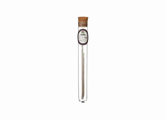A clear glass tube with a cork stopper, containing a small object, possibly a piece of jewelry or a decorative item.