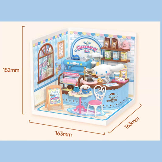 The image is a miniature diorama of a whimsical cafe, featuring a variety of colorful and whimsical elements such as a coffee machine, chairs, tables, and other decorative items. The diorama is set against a light blue background, and the dimensions of the diorama are provided in millimeters.