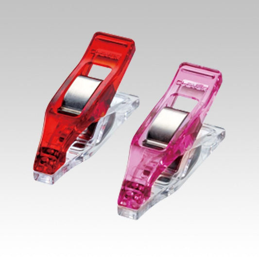 two clear plastic clips, one red and one pink, attached to a gray background.