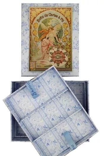 a decorative box with a floral pattern and an illustration of a fairy on the lid. The box is open, revealing its interior, which appears to be lined with blue and white patterned paper.