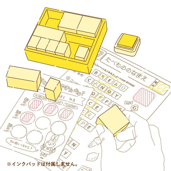 The image is a collage of various objects, including a yellow box, a yellow stamp, and a hand holding a yellow block. The objects are arranged in a way that suggests they are being used or interacting with each other. The image does not contain any text, and the objects are not described in detail. The overall composition is simple and straightforward, focusing on the interaction between the objects rather than providing specific details about each item.