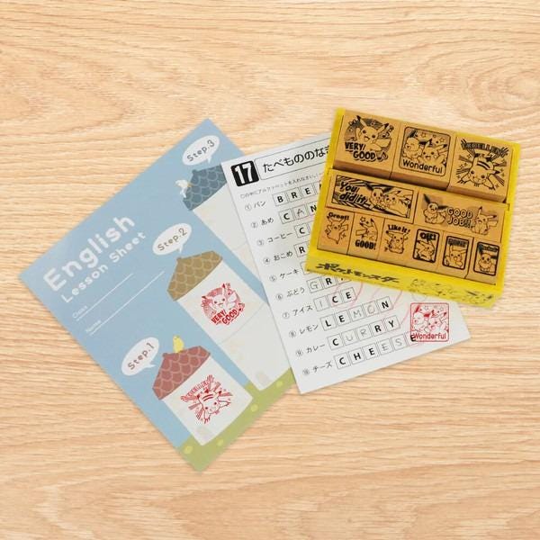 a blue sheet of paper with instructions for a lesson, a set of yellow stickers with Pokemon characters, and a white sheet with Japanese text.
