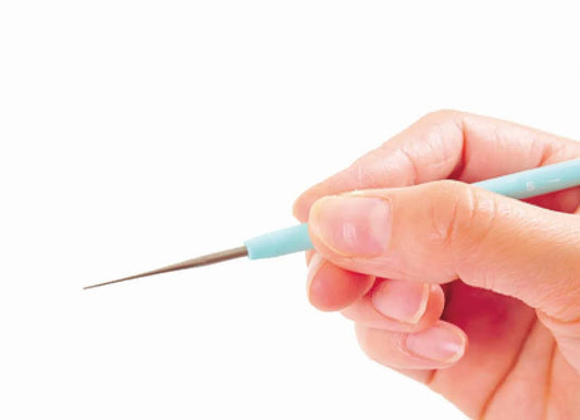 A hand holding a blue crochet hook.