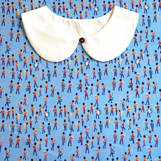 a white collar with a button, set against a background of a repeating pattern of people playing musical instruments, creating a lively and dynamic visual composition.