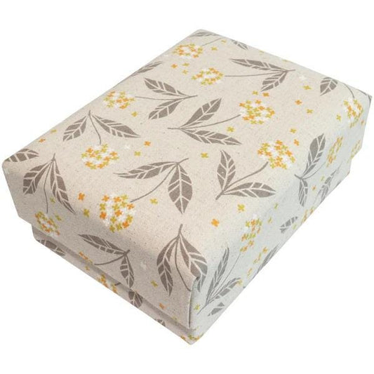 A rectangular gift box with a beige fabric pattern featuring leaves and flowers in shades of orange and yellow.