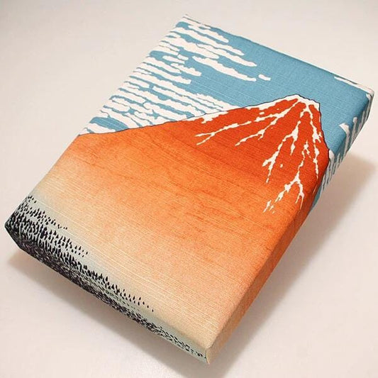 a rectangular piece of fabric with a vibrant design depicting a mountain landscape.