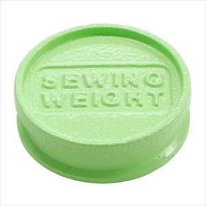 A green plastic object with the text "SEwing WEIGHT" embossed on it.