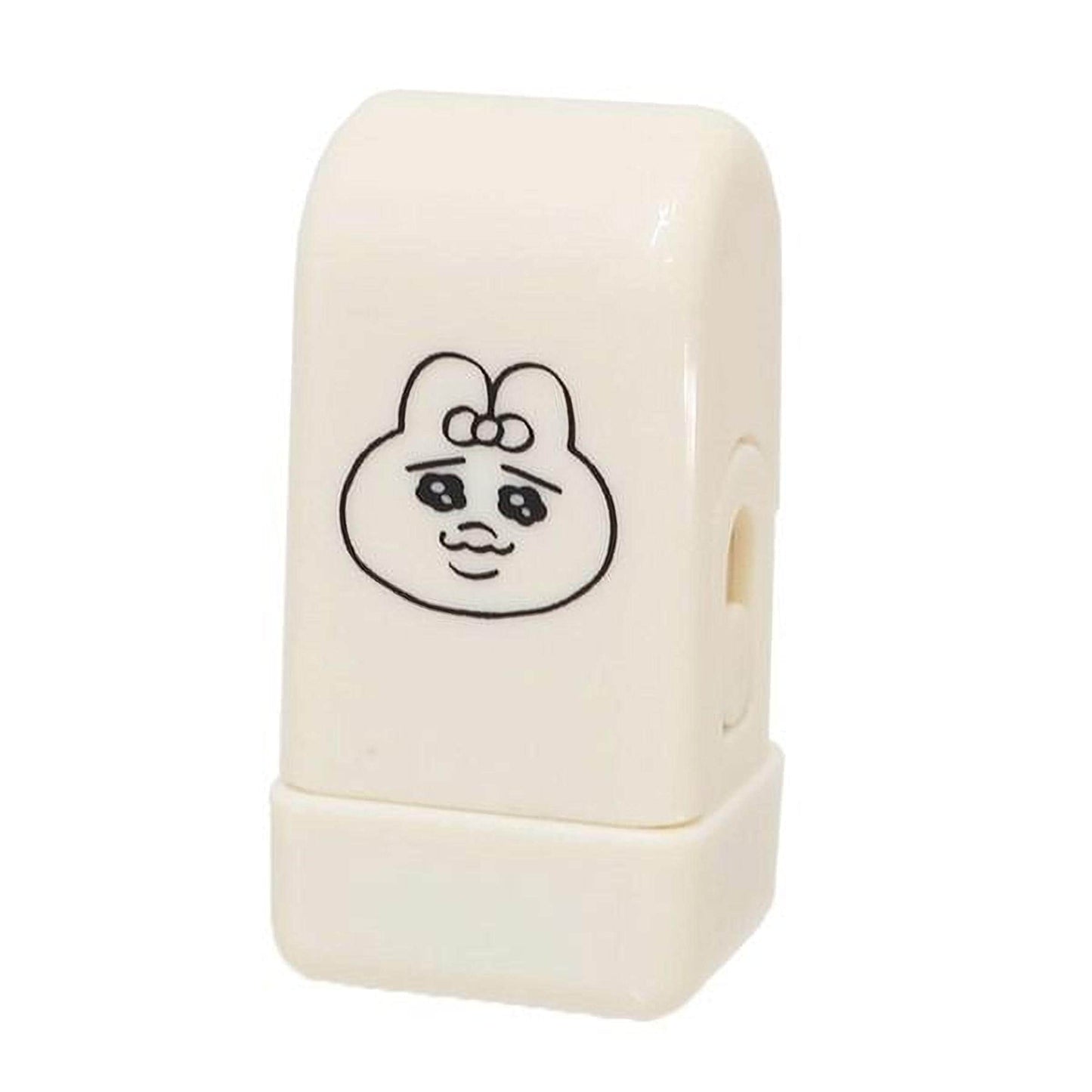 A white, rectangular object with a black cartoon character design on it.