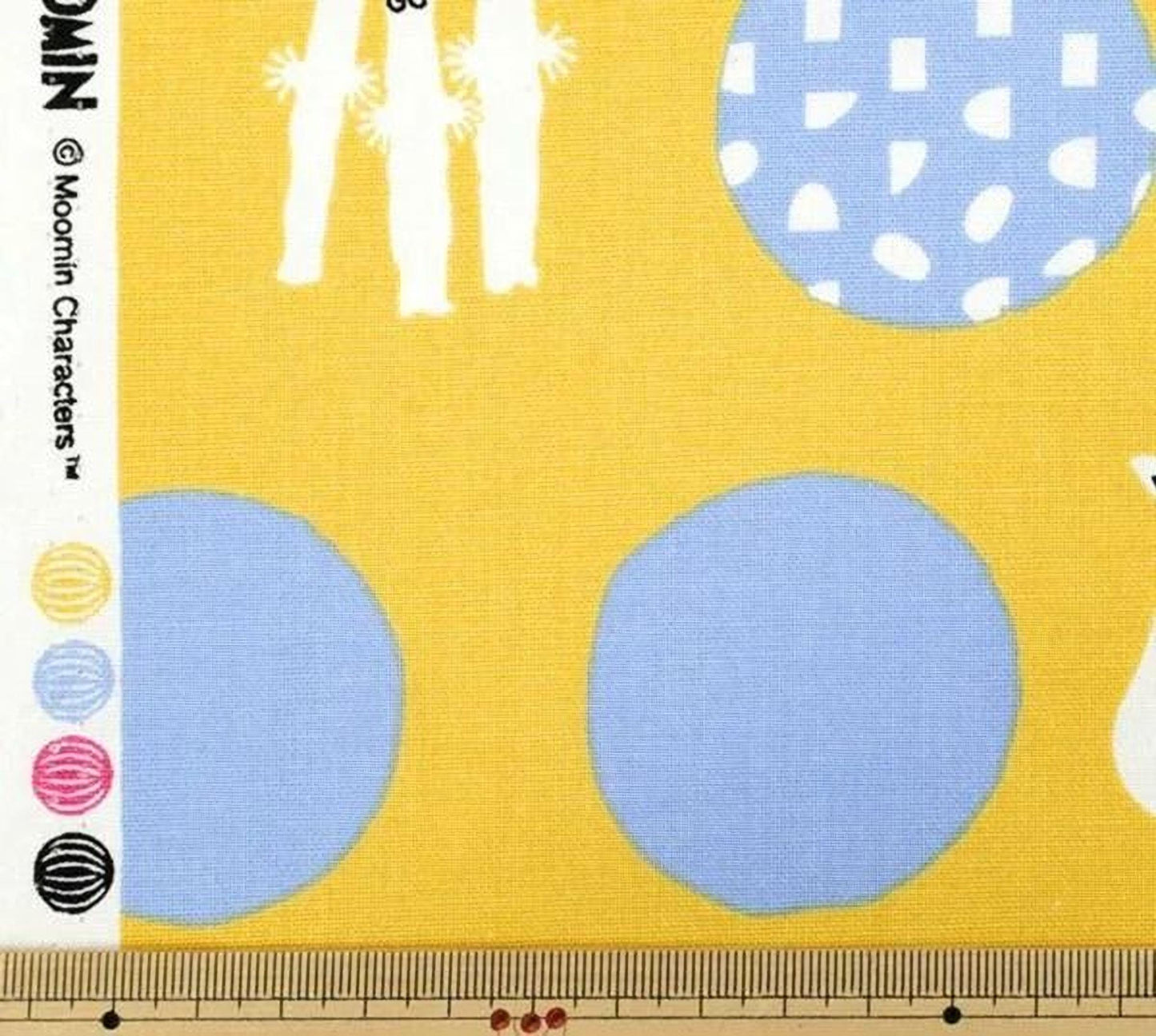 The image is a fabric with a yellow background and various colorful shapes, including blue circles and other abstract designs.
