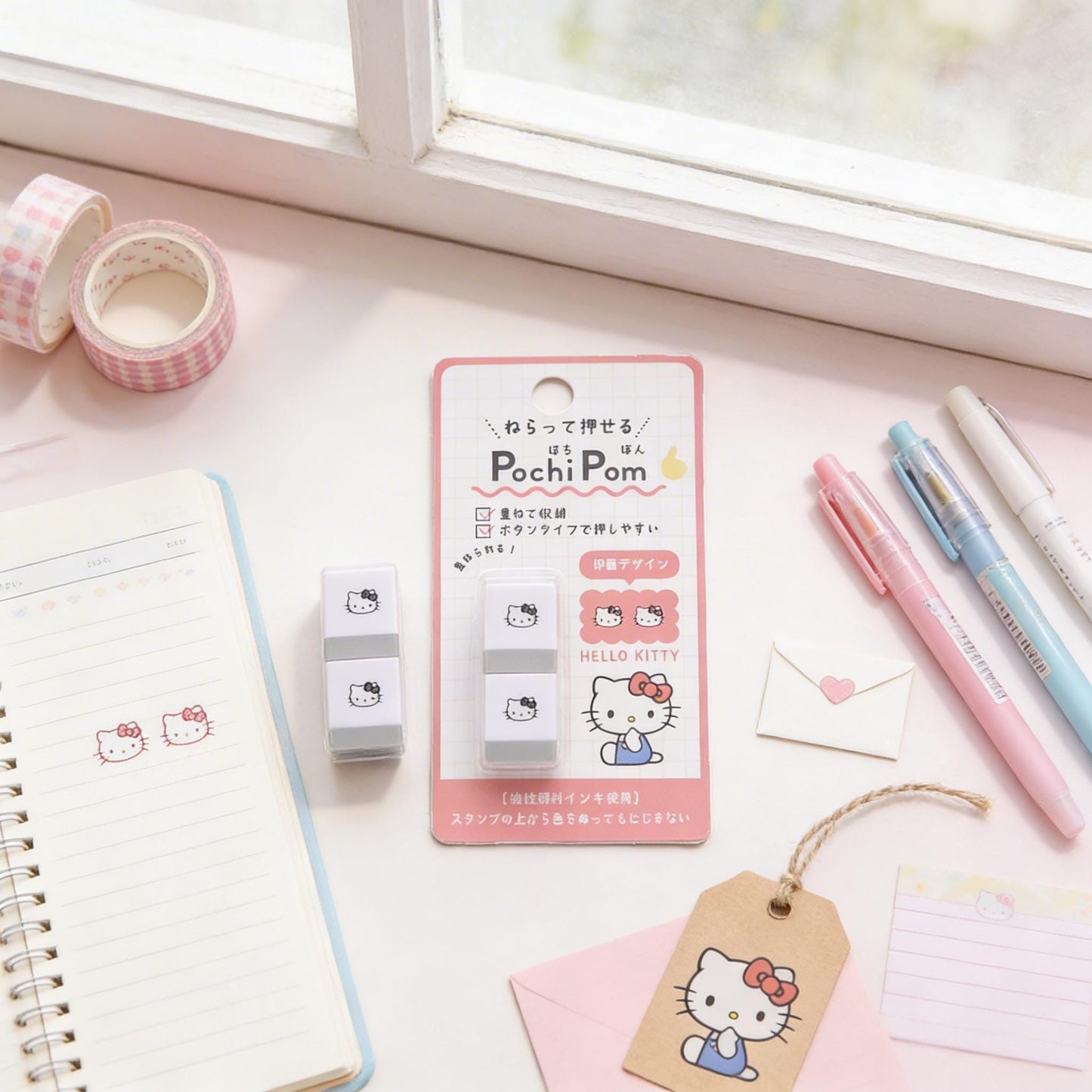 a collection of Hello Kitty-themed items, including a Hello Kitty eraser, a notebook, pens, and other stationery.
