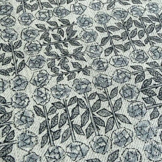 a close-up view of a fabric with a repeating pattern of black and white flowers and leaves.