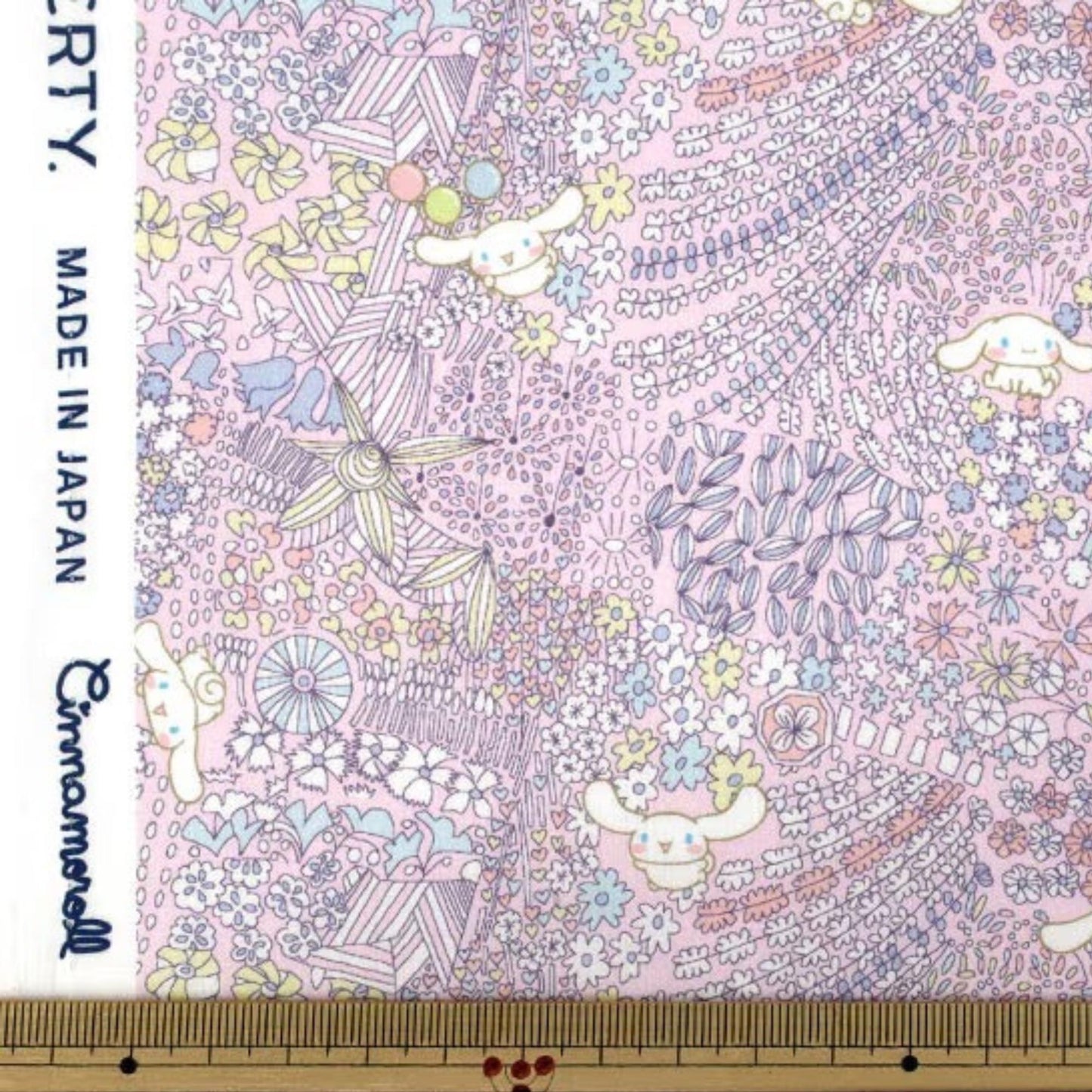 The image is a fabric with a colorful, whimsical pattern featuring various flowers, leaves, and other decorative elements. The fabric appears to be handmade and is likely used for clothing or textile purposes.