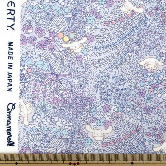 The image is a fabric with a colorful, whimsical pattern featuring various cartoon-like characters and floral designs.
