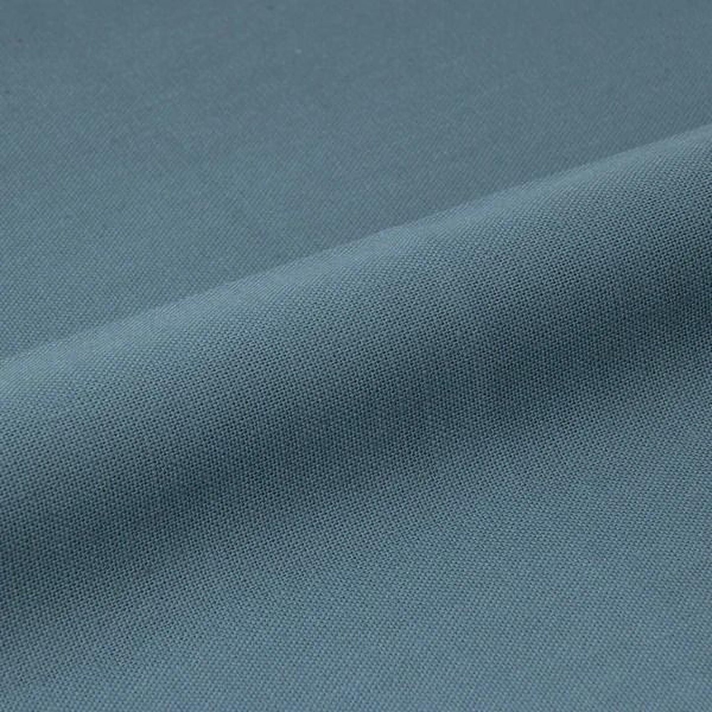 A close-up view of a textured fabric, likely a piece of clothing or textile, with a smooth, curved surface.