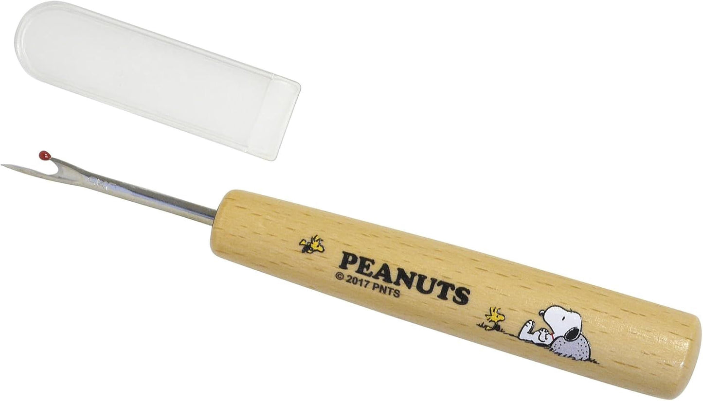 A Peanuts-themed sewing tool with a wooden handle and a clear plastic case.
