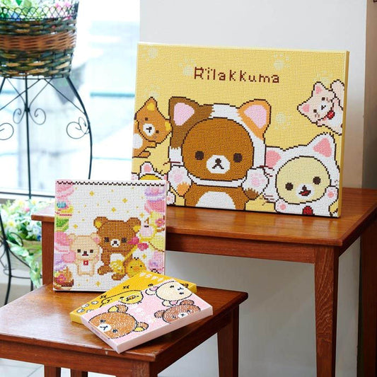 a collection of three different items, including a framed picture of a cartoon character, a small box with a cartoon character, and a small wooden table with a pink box on it.