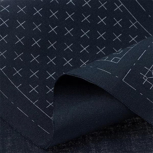 a close-up view of a dark fabric with a pattern of white crosses or lines on it.