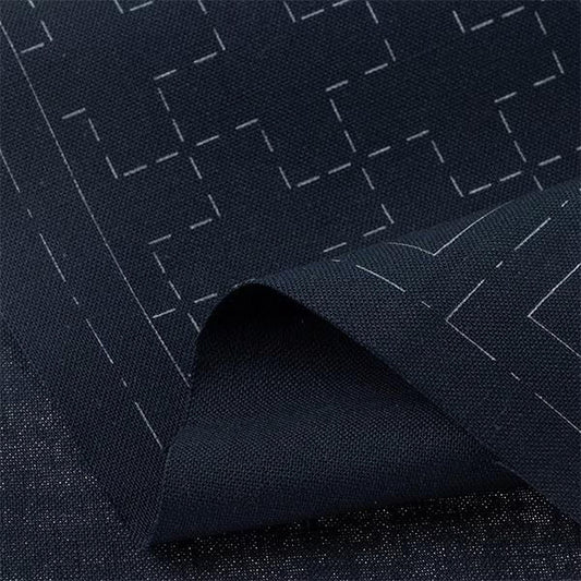 a close-up view of a dark fabric with a geometric pattern, featuring white lines and shapes.