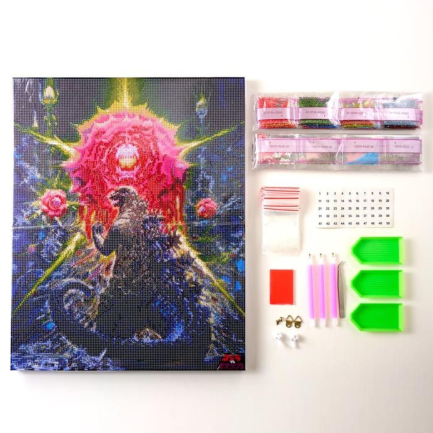 a mosaic artwork featuring a large, colorful flower surrounded by smaller flowers and leaves. Various tools and supplies are laid out next to the mosaic, including a diamond tool set, a green tool, and a red tool.