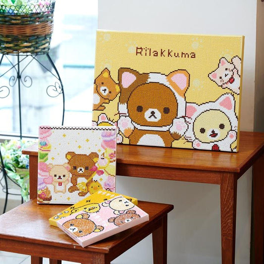 a collection of three different items, including a framed picture of a cartoon character, a small box with a cartoon character, and a small wooden table with a pink box on it.