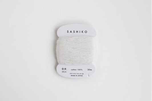 A spool of white thread labeled "SASHIKO" against a white background.