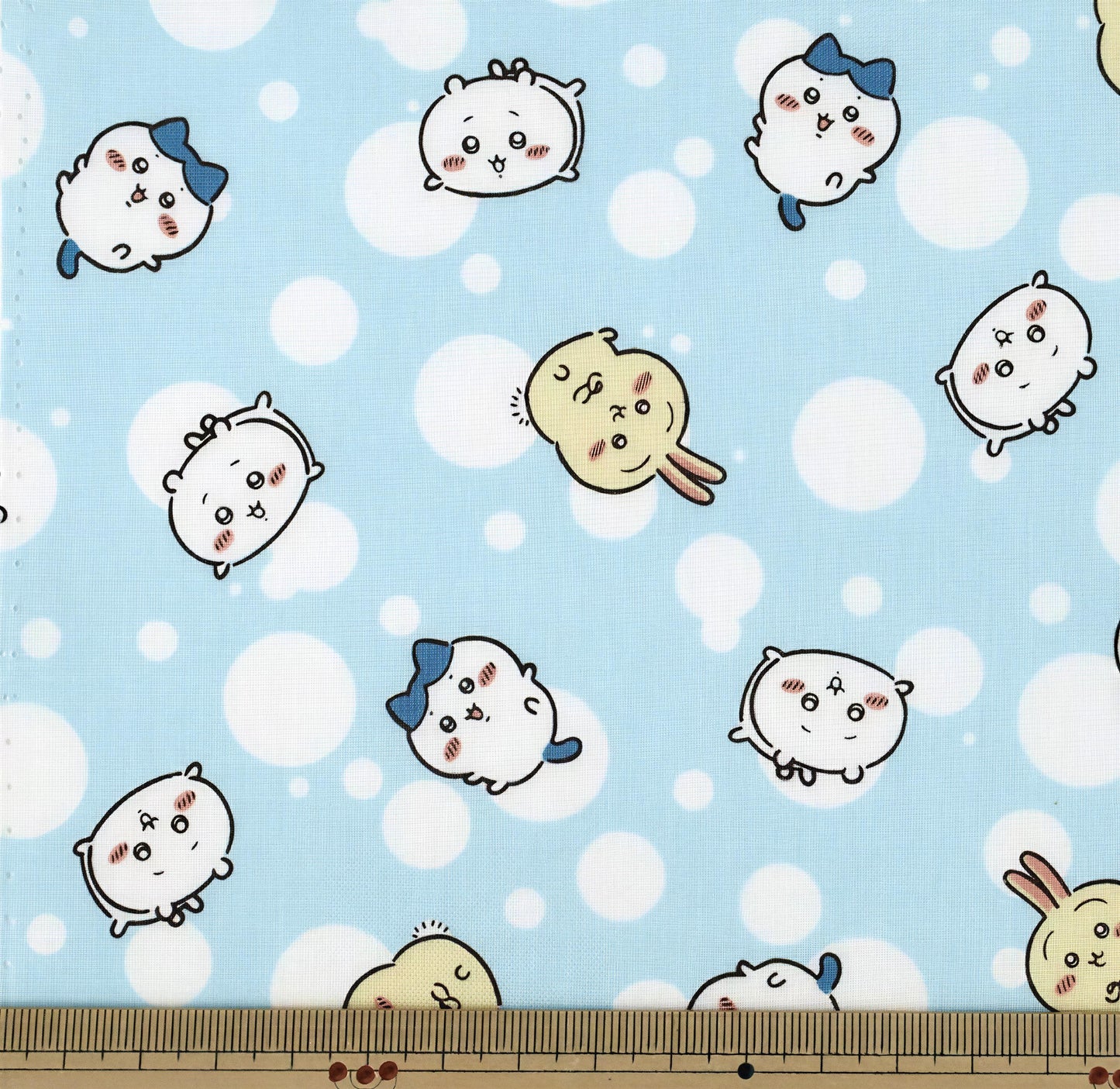 a pattern of cartoon-style animals, including rabbits, against a light blue background with white polka dots.
