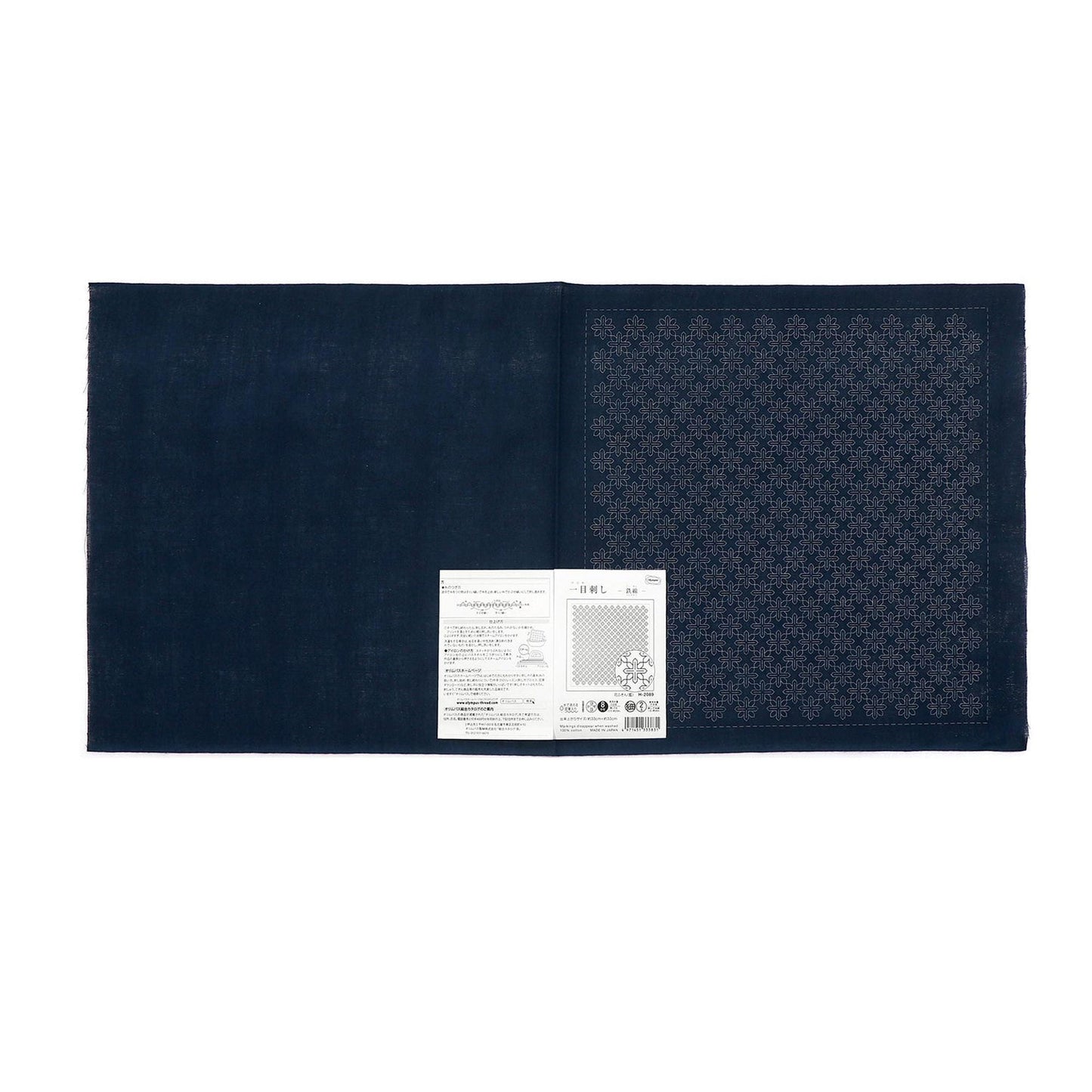 a dark blue fabric with a white label attached to it, which appears to be a piece of paper or a printed document.