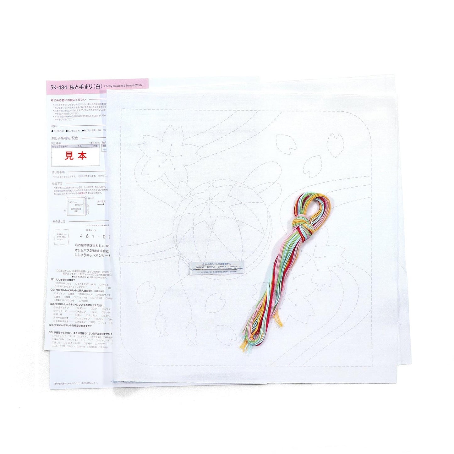 a sewing kit with instructions and a spool of thread, along with a piece of paper with a drawing or pattern.