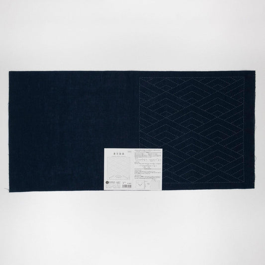 The image is a dark blue fabric with a white label attached to it, which appears to be a piece of paper with text and diagrams.