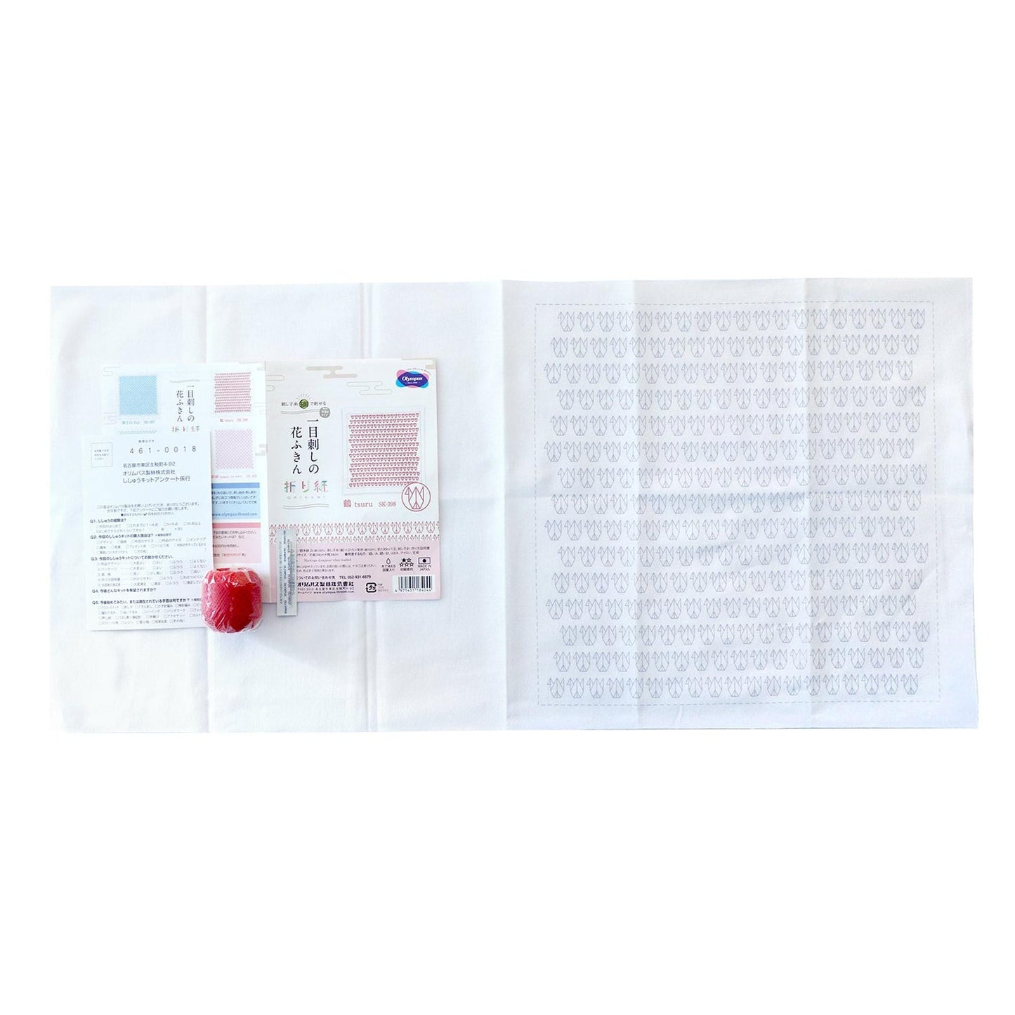 a white cloth with a red apple and some text printed on it, along with a small red object.