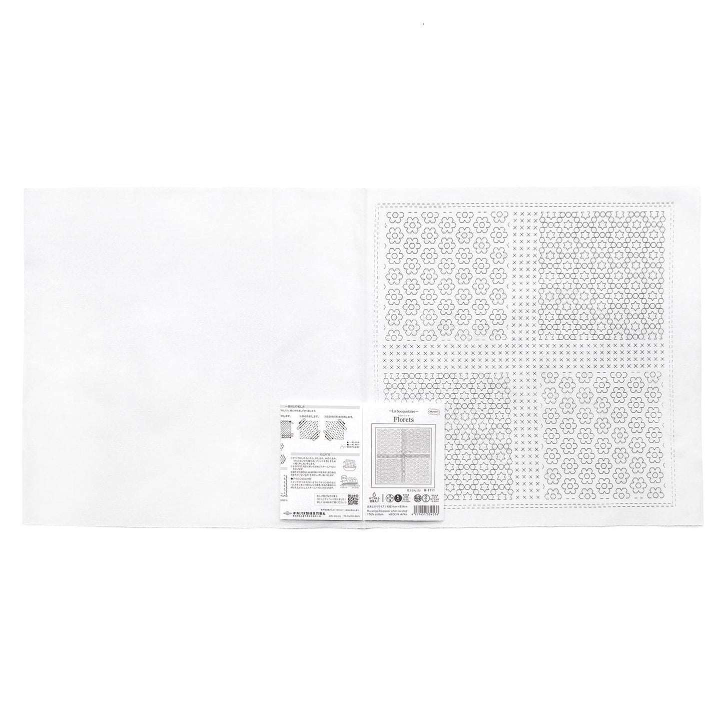 The image is a white square with a pattern of small circles or dots on it. There is also a small white label or piece of paper with text and diagrams next to the square.