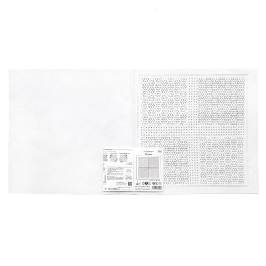 The image is a white square with a pattern of small circles or dots on it. There is also a small white label or piece of paper with text and diagrams next to the square.