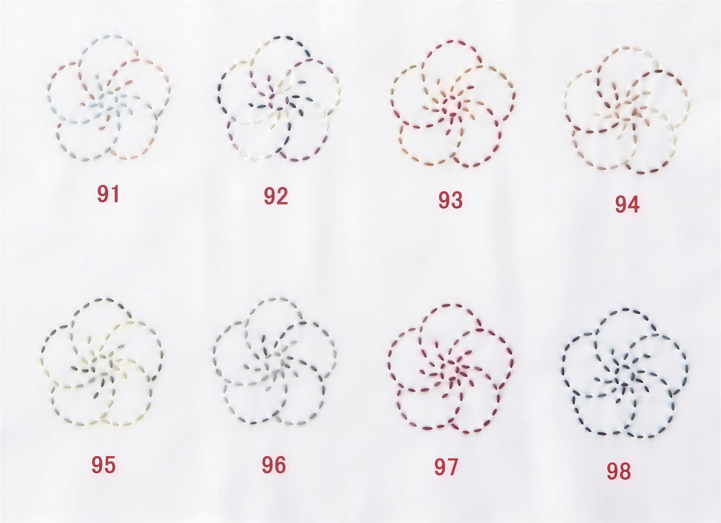 a collection of eight flower-like patterns, each with a unique color and design, arranged in a grid format.