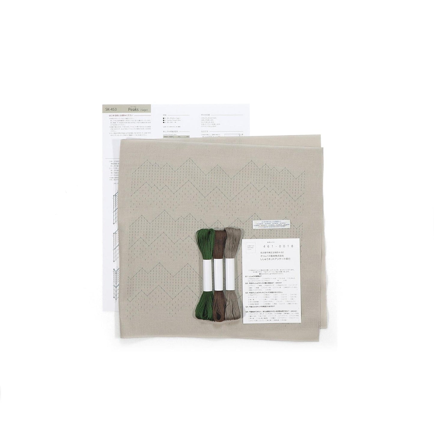 a beige fabric with a zigzag pattern, along with some thread and a piece of paper with text and numbers.
