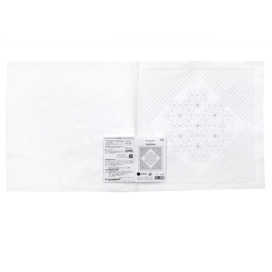 The image is a white square with a black and white pattern on it, and there is a small label or package attached to the right side of the square.