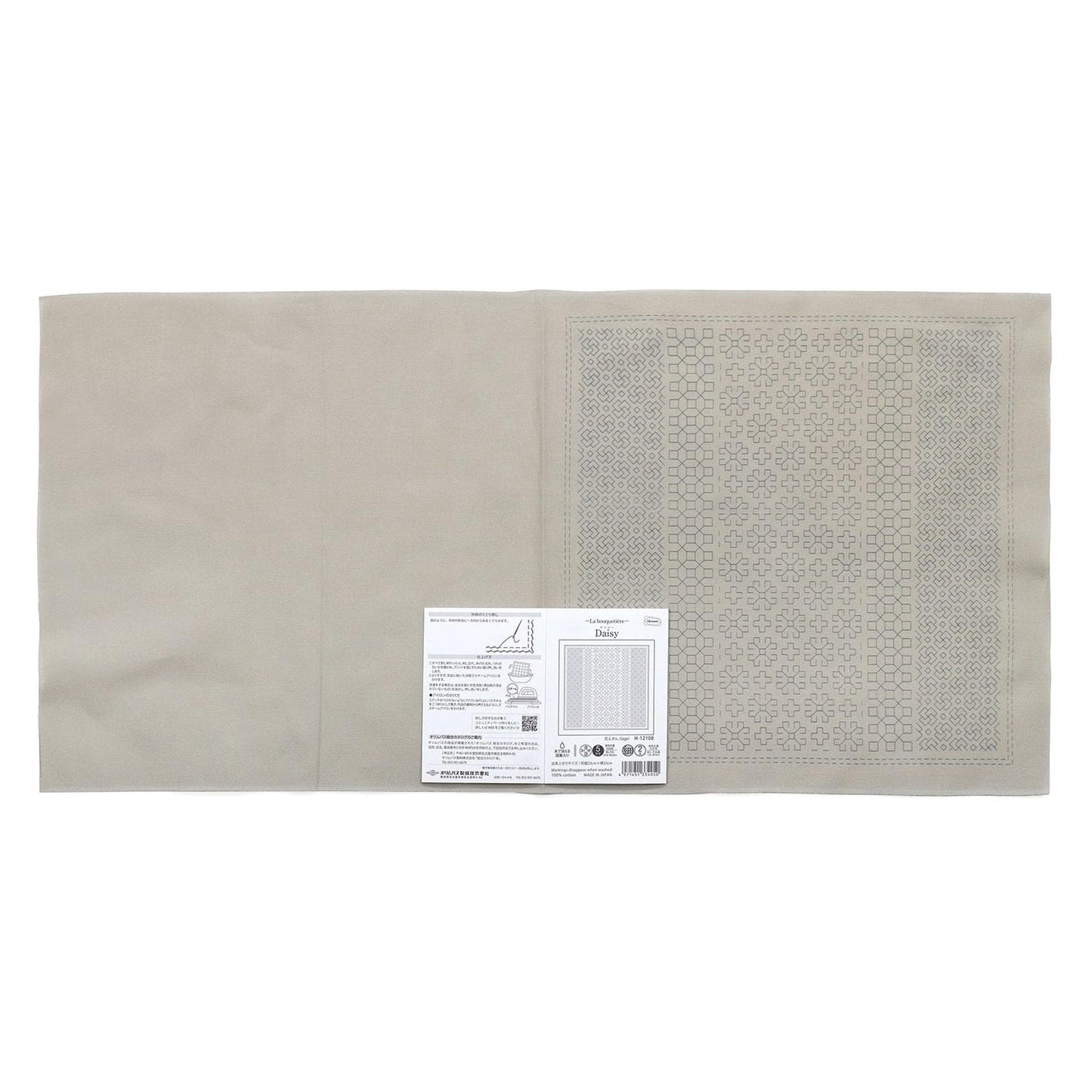 a beige fabric with a printed pattern on it, placed next to a small white label with text.