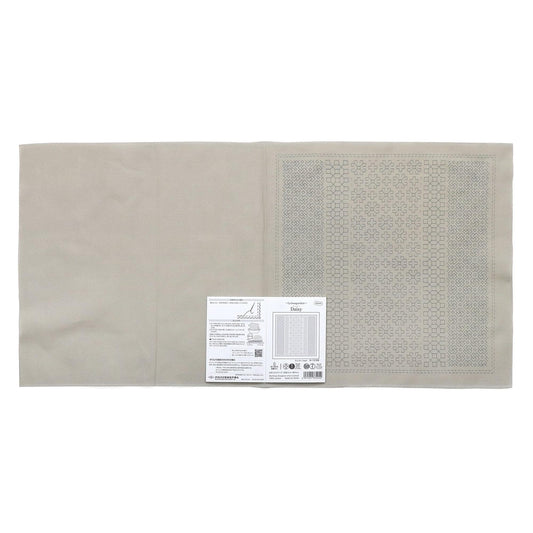 a beige fabric with a printed pattern on it, placed next to a small white label with text.