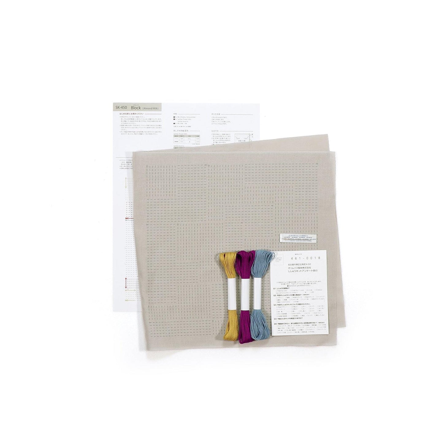 a cross-stitch kit with instructions and materials, including a beige background, a piece of paper with instructions, and several spools of thread in various colors.