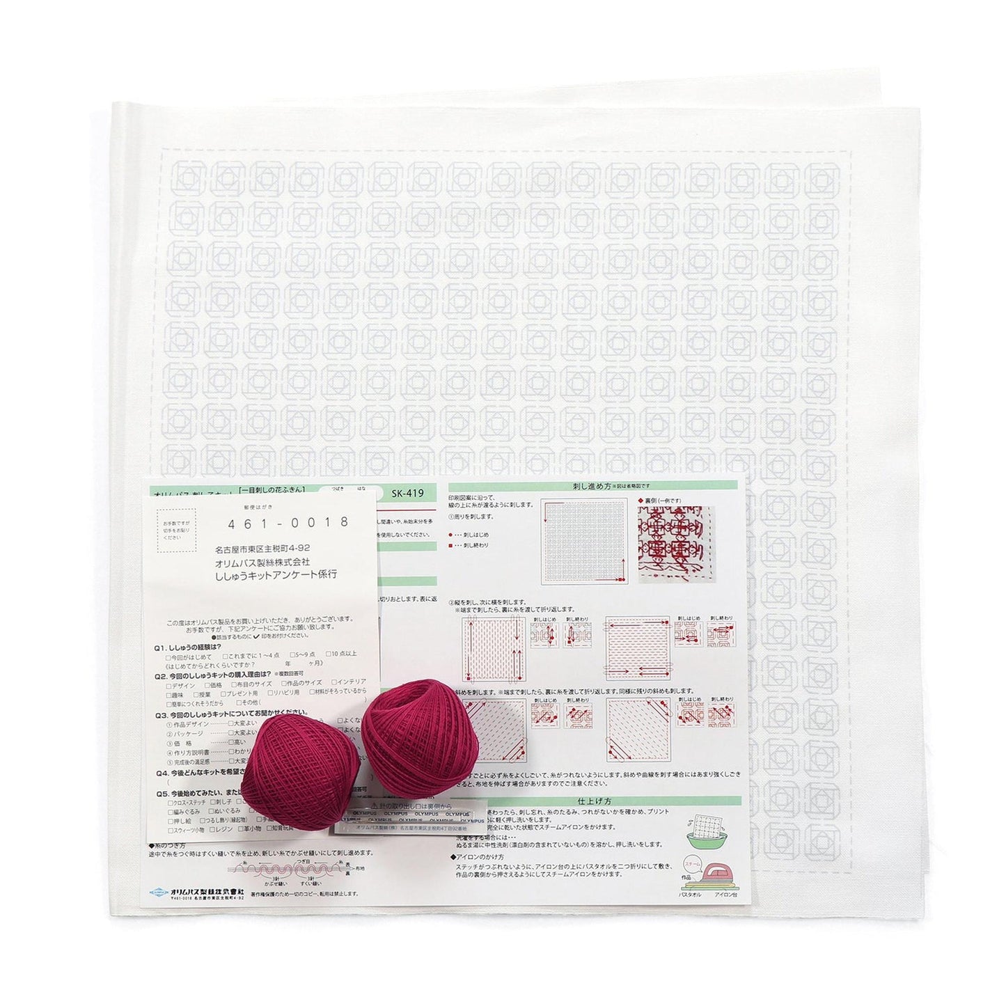 a white paper with instructions and two balls of red yarn placed on top of it.